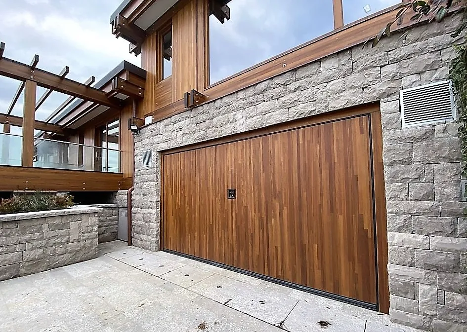Porta da garage Silvelox in legno a doghe verticali su una casa in pietra